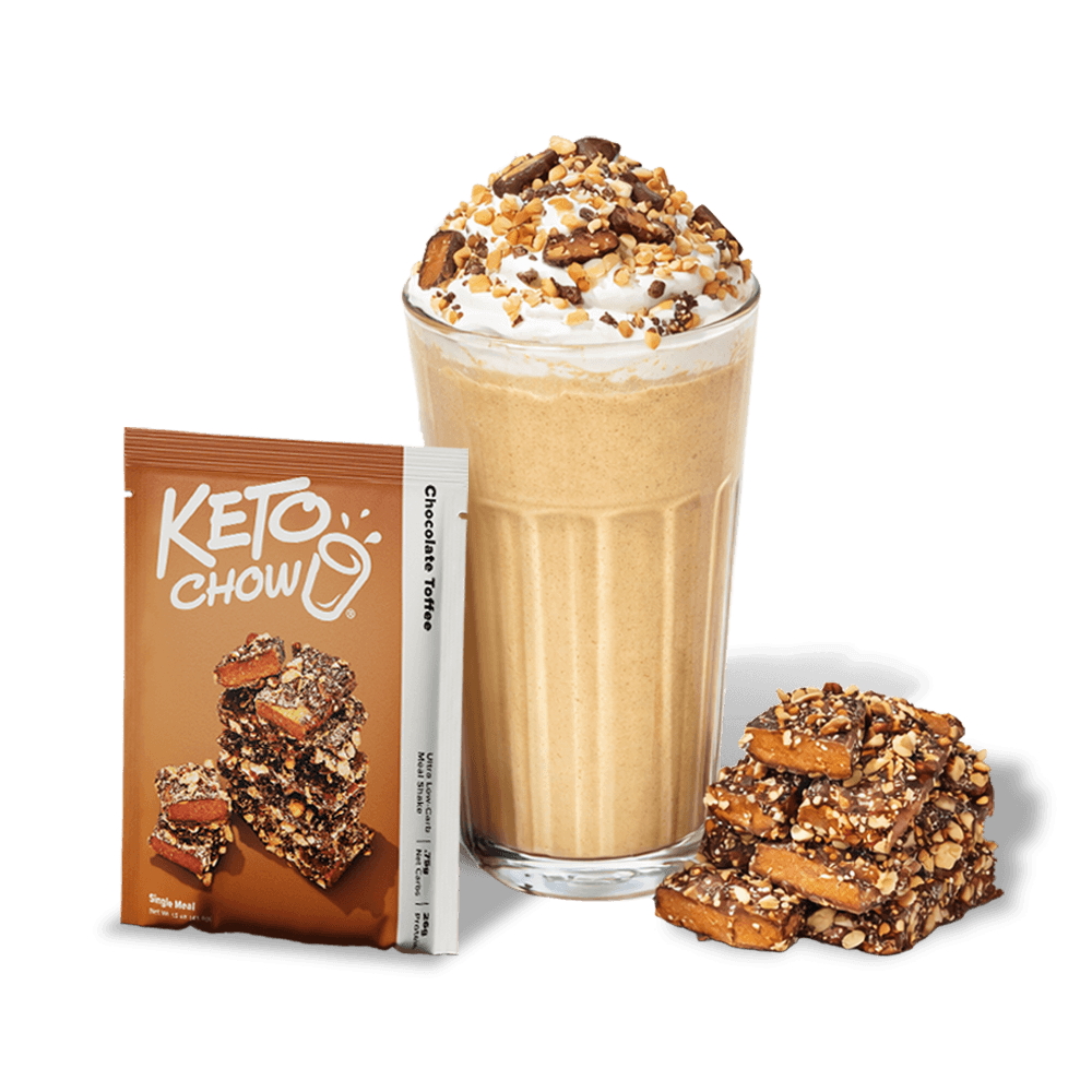 KETO CHOW Chocolate Toffee meal shake in a glass with whipped cream and nuts. A brown KETO CHOW pouch, white Chocolate Toffee stick pack, and stack of toffee pieces are present.